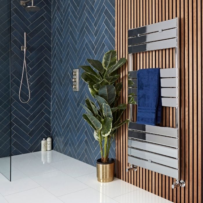 Elizabeth HTR in bathroom full shot chrome heated towel rail on a wooden bathroom wall