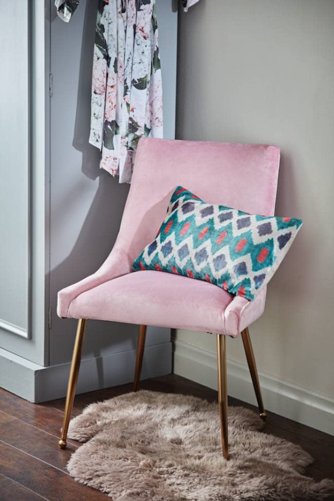 pink velvet chair in a bedroom
