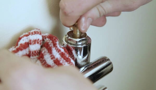 a man turning the bleed nipple of a radiator anticlockwise