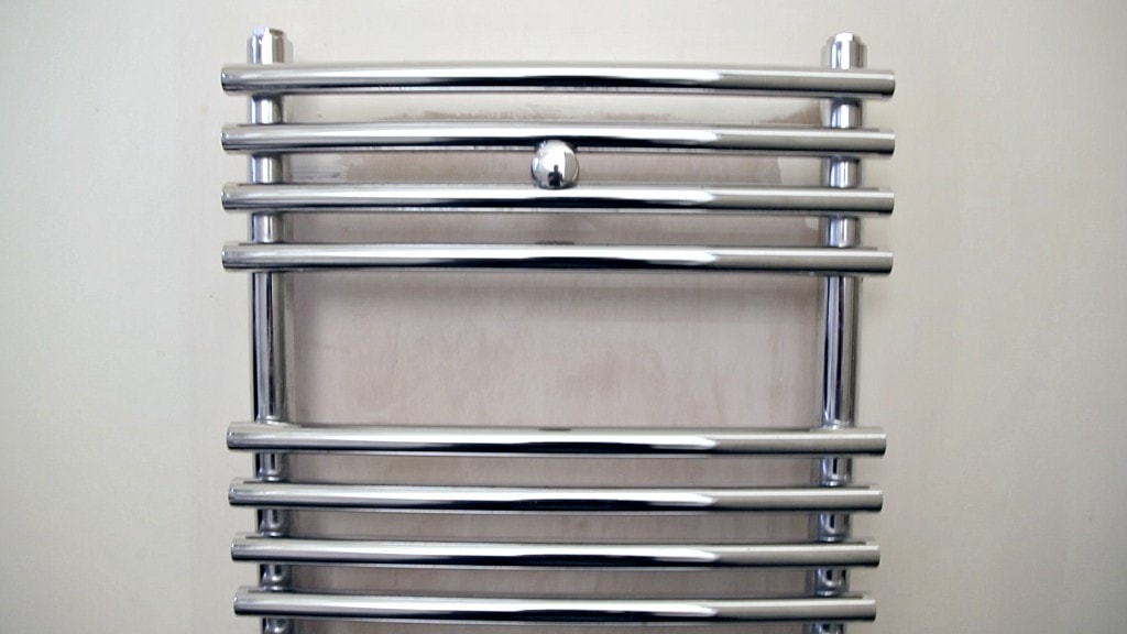 Front on shot of a heated towel rail on a wall in a bathroom