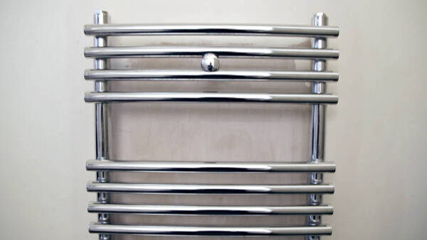 Front on shot of a heated towel rail on a wall in a bathroom