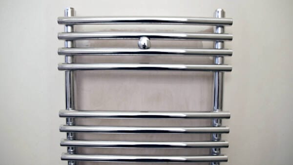 Front on shot of a heated towel rail on a wall in a bathroom