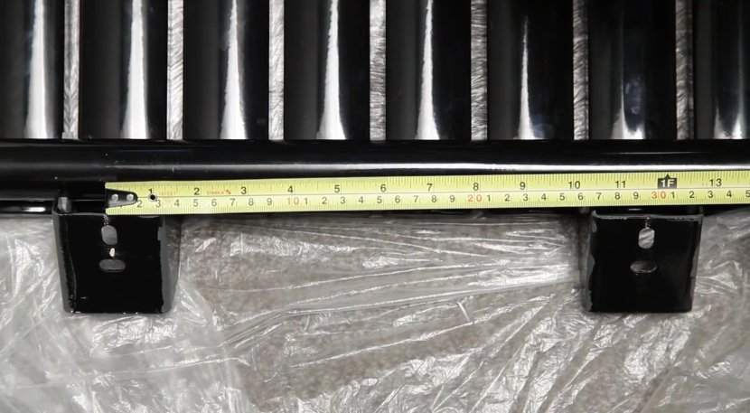 A tape measure showing the distance between two radiator brackets