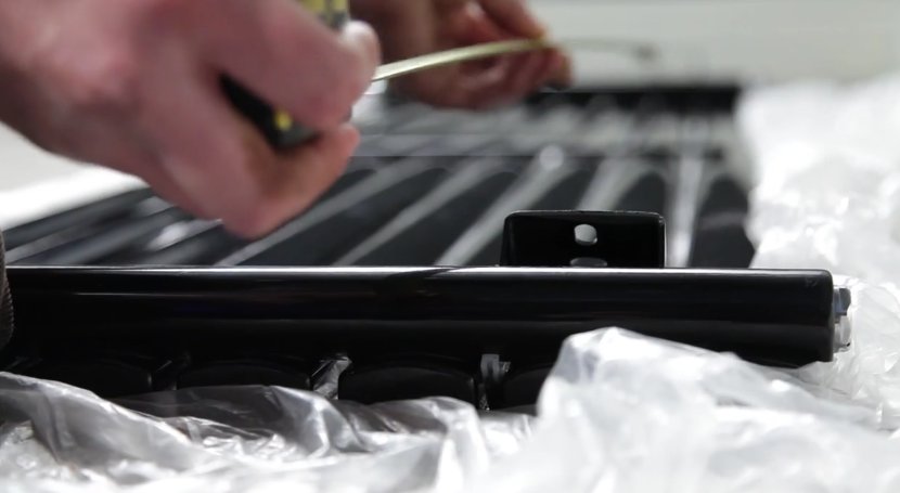Man using a tape measure to calculate the length of a designer radiator