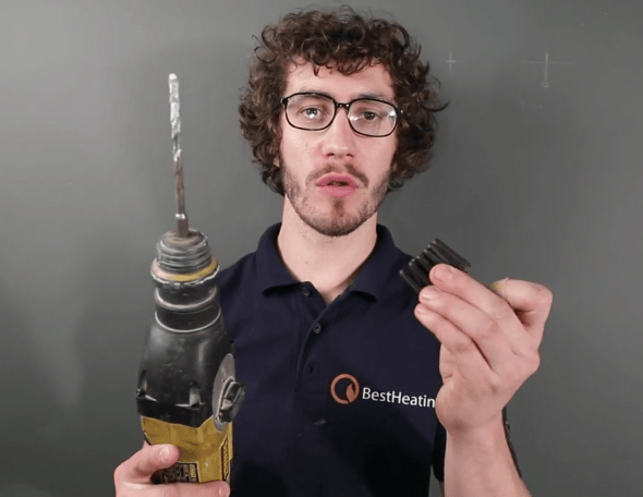 Man with glasses holding a drill and a set of rawlplugs