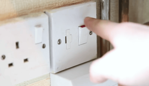 Man switching off a central heating system at the mains