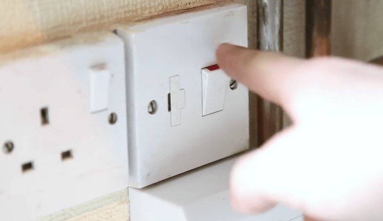 Man switching off a central heating system at the mains