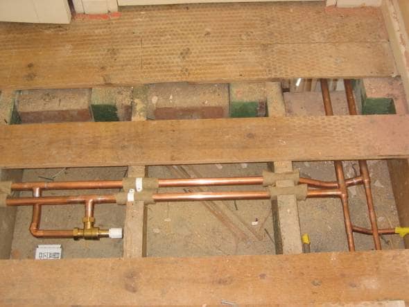 Pipework exposed under some floorboards