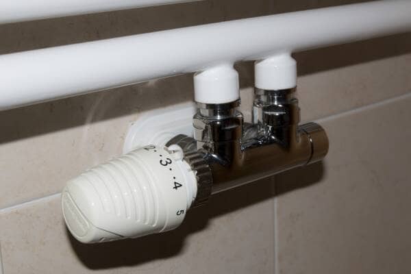 An H block valve TRV fitted to white pipework and set to number 3