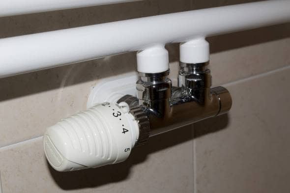 An H block valve TRV fitted to white pipework and set to number 3