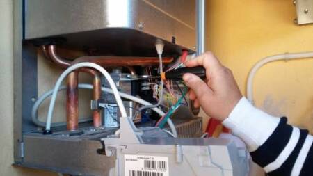 Gas central heating boiler being serviced Gas central heating boiler being serviced