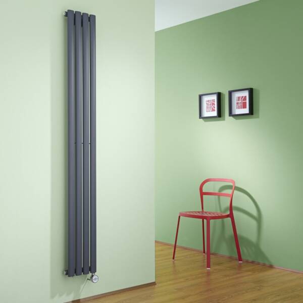 Tall vertical grey electric radiator on a green wall