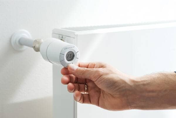 a hand turning a devolo home control radiator thermostat