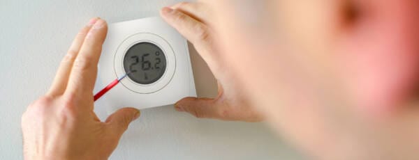 man installing the genius home thermostats SMART hub