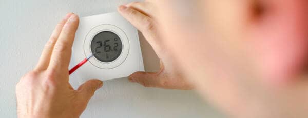 man installing the genius home thermostats SMART hub