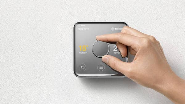 a hand operating a hive active heating 2 thermostat