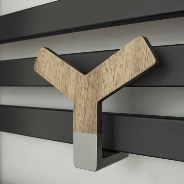 The Lazzarini Y Wood attached to a heated towle rail on a white background