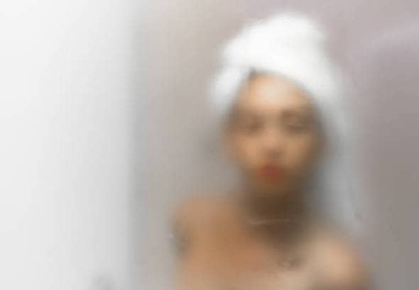 a woman wearing a towel on her head in a steamy bathroom