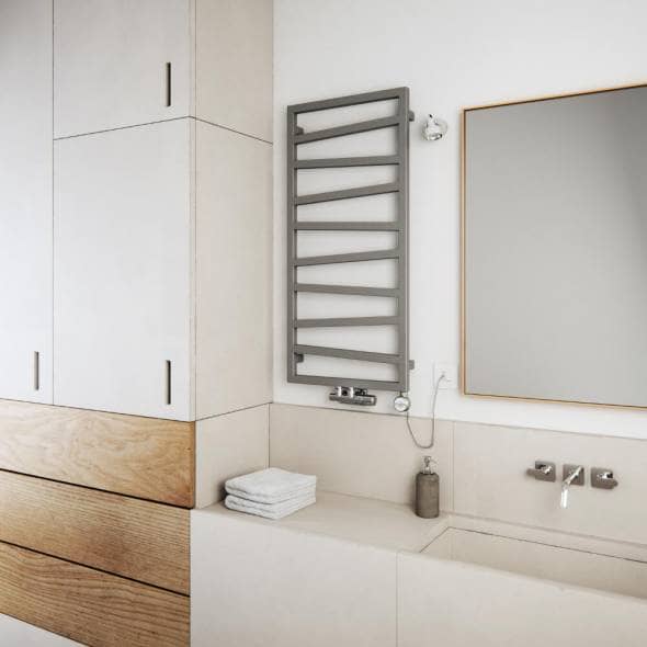 A silver Terma ZigZag dual fuel towel radiator in a bathroom next to a mirror