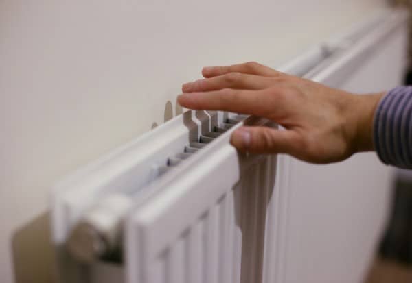 hand on radiator check hand on white convector radiator checking heat output