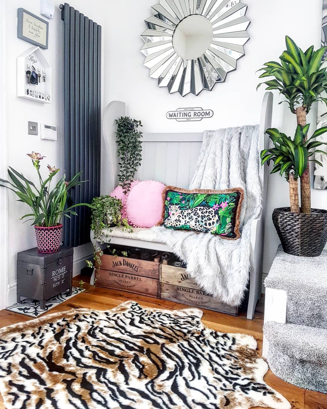 Anthracite radiator in a hallway Vertical anthracite radiator in a busy hallway with mirror and plant and seat with cushions