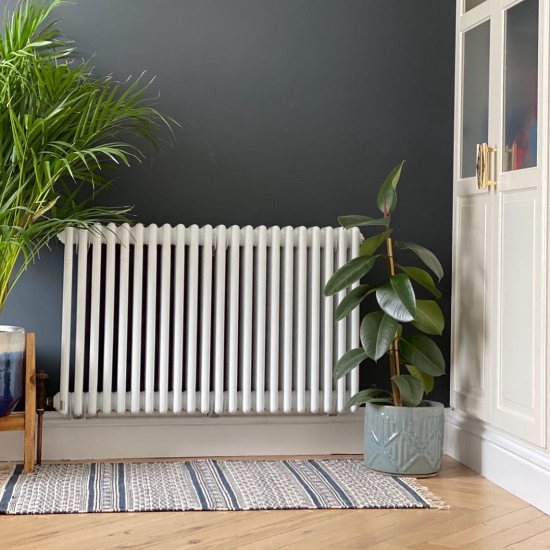 white column radiator on a navy wall