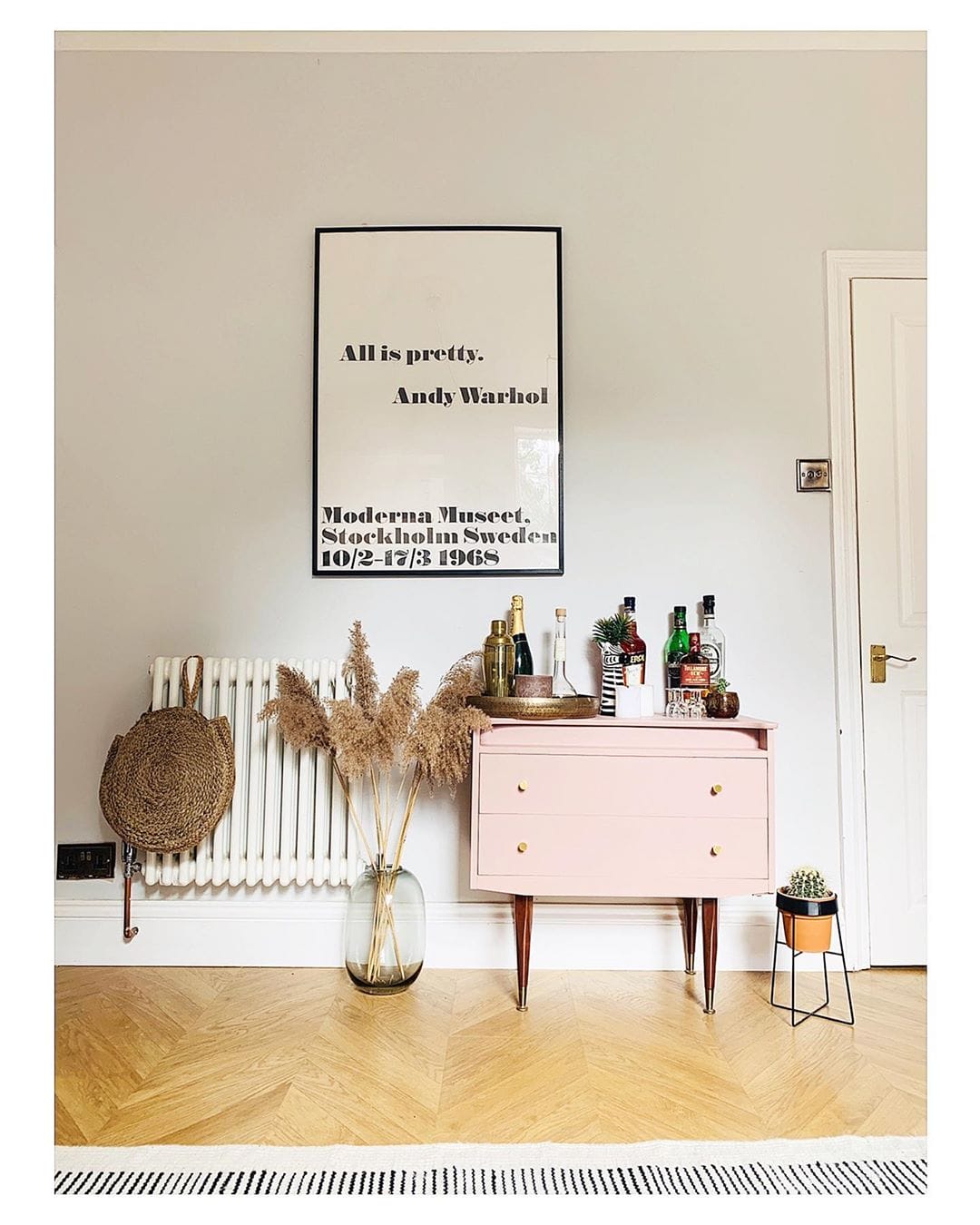 white radiator next to a pink bar cart