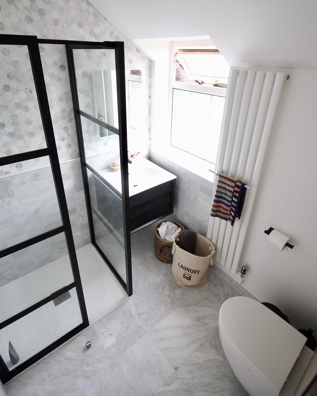 narrow vertical radiator in a small bathroom from above narrow vertical white radiator in a small bathroom from above