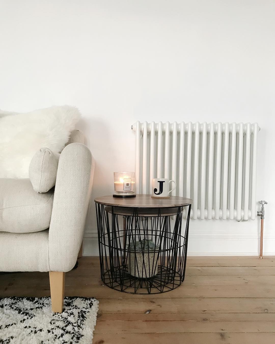 white column radiator next to a cream sofa