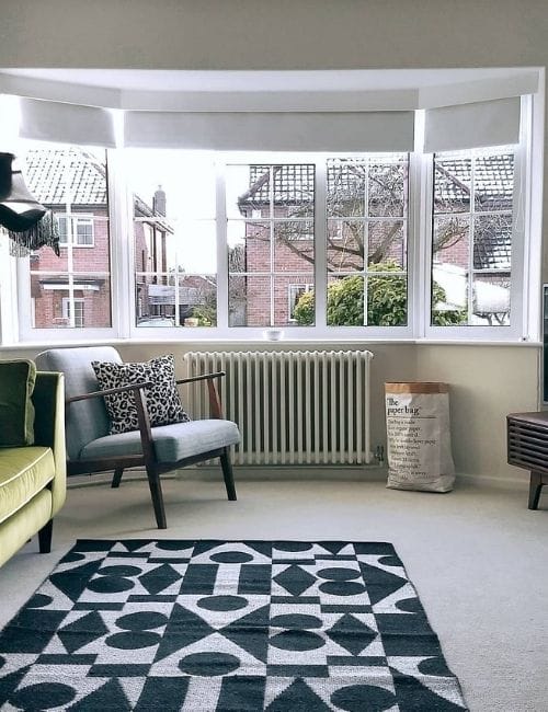 white column radiator under a living room window