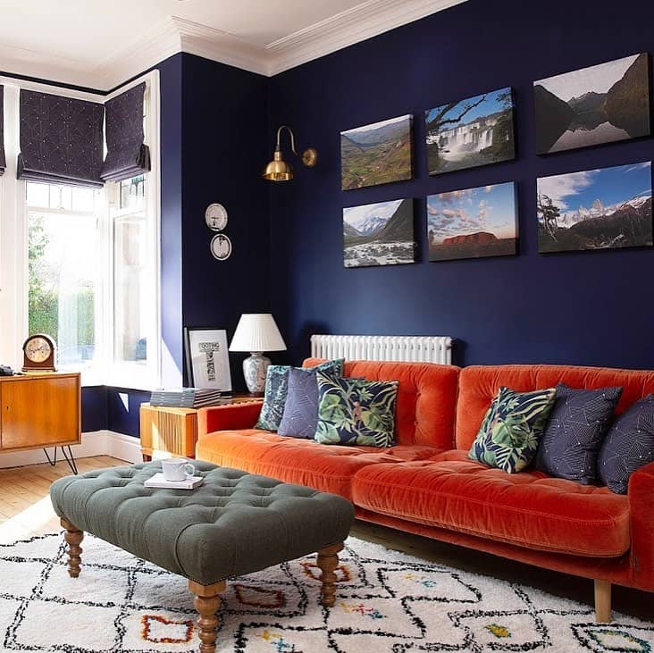 white column radiator behind an orange velvet sofa