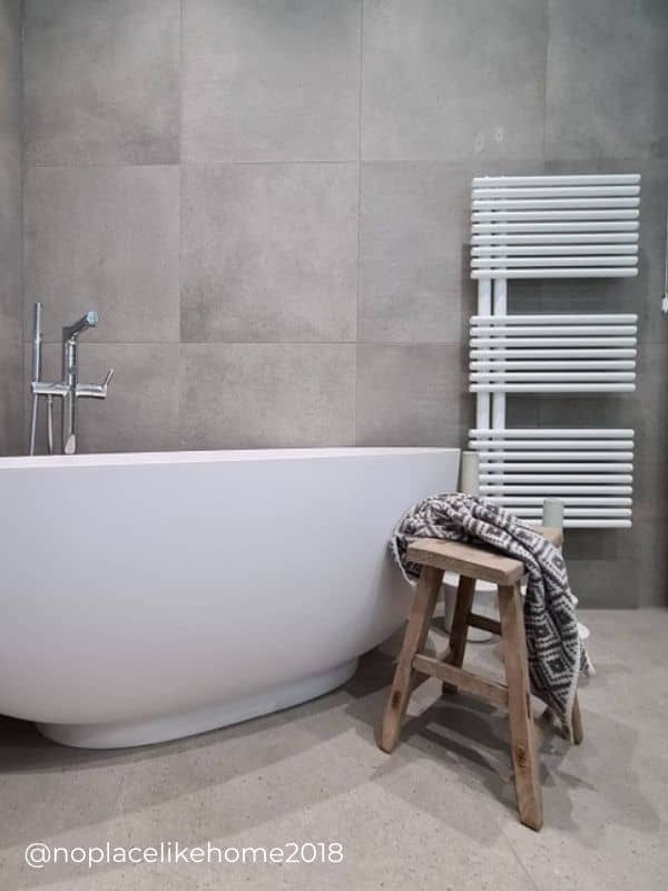 modern white heated towel rail in a minimal bathroom