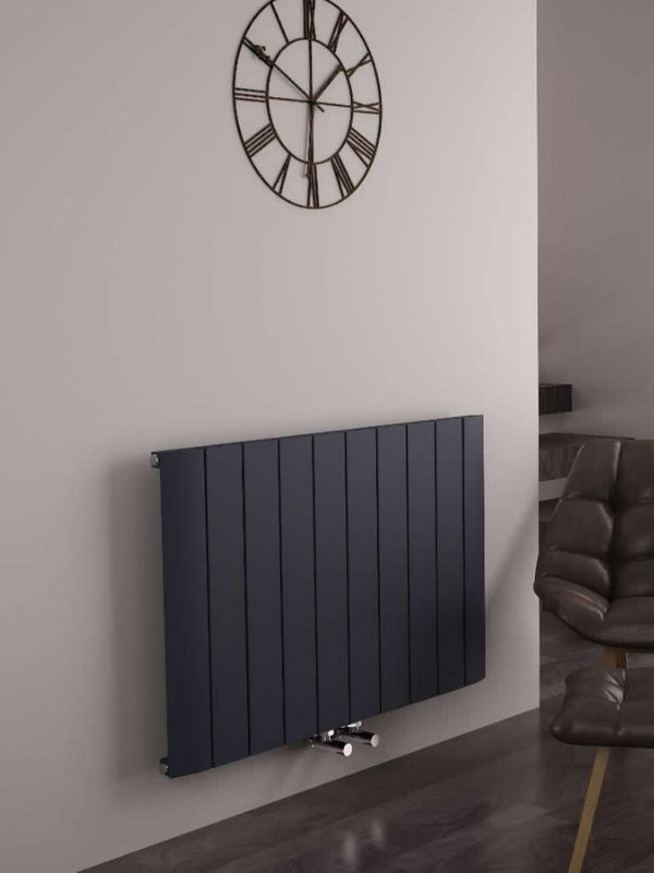 a modern anthracite horizontal radiator on a grey wall
