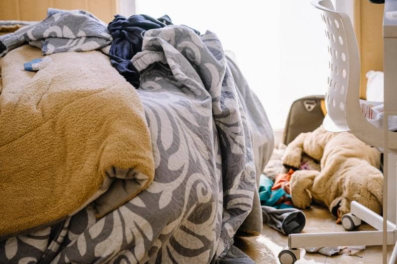 Messy teen room with clothes lying on the floor.