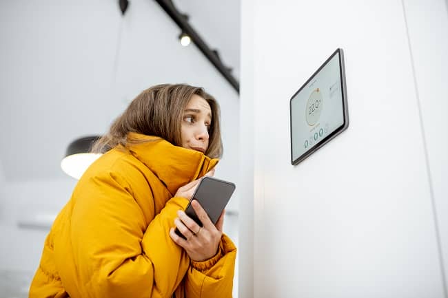 A woman wrapped up against the cold after her boiler stops working in winter