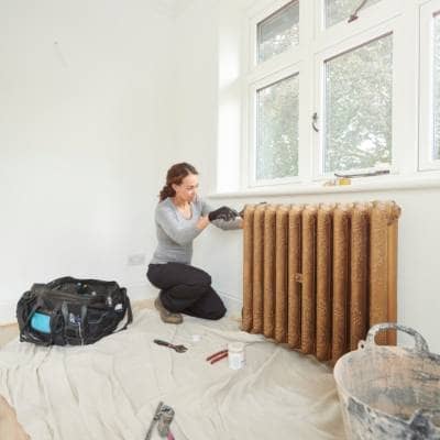 woman installing a cast iron radiator