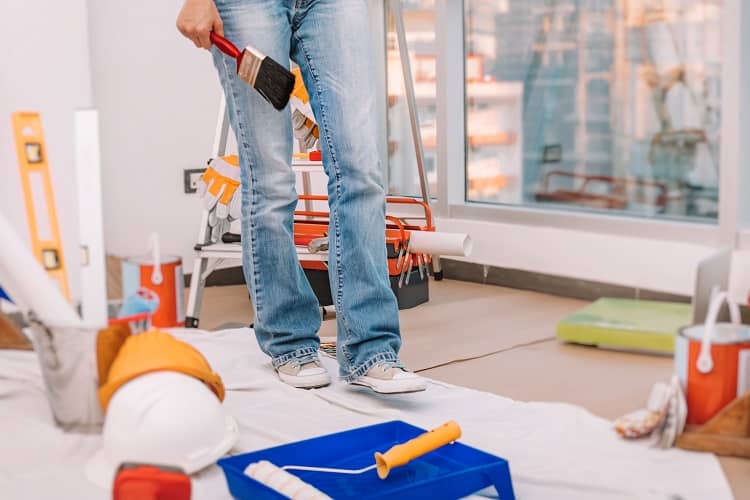 Woman with paint Brush for Wall Painting. Interior Design of the New Apartment. Making Renovation in the Flat.