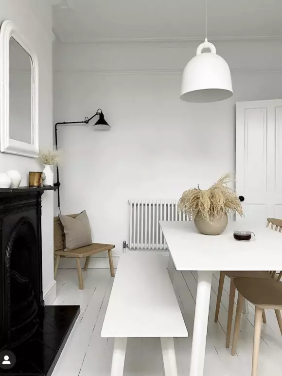 an image of a white dining area with a white column radiator in the background
