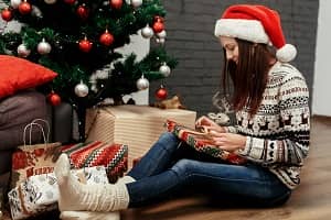 Girl under a christmas tree wearing thick socks and a jumper Girl under a christmas tree wearing thick socks and a jumper
