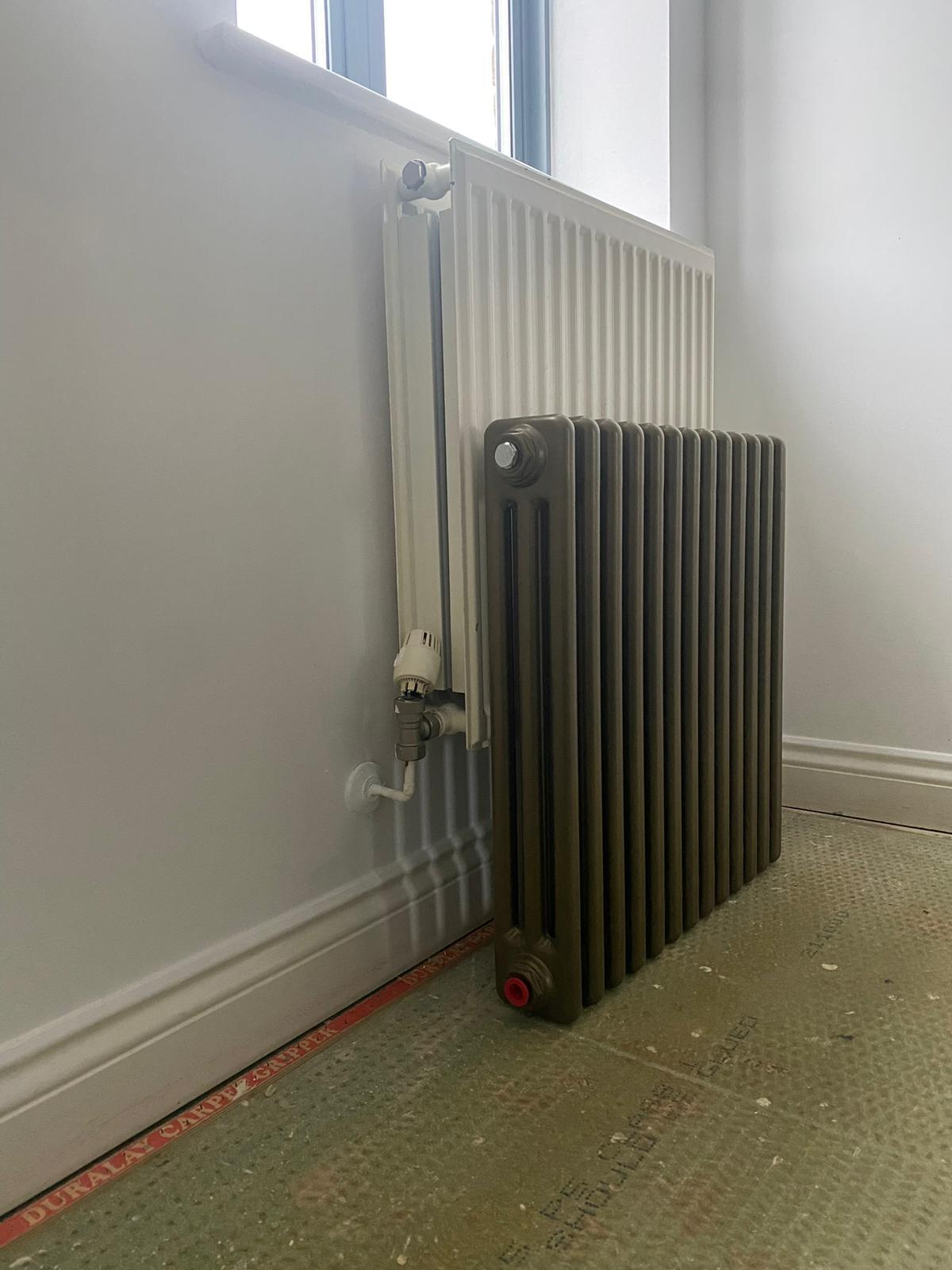 bronze column radiator in front of an old convector