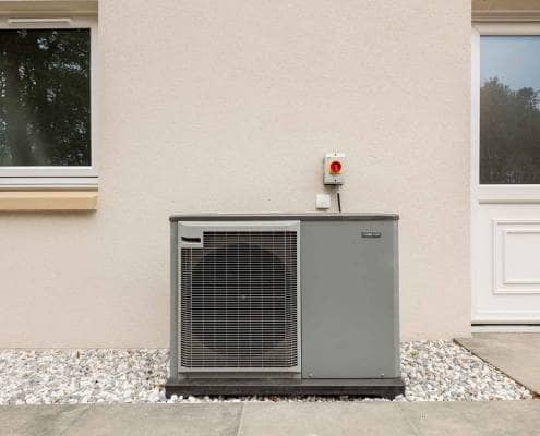 Grey air source heat pump Grey air source heat pump nearby white back door and window