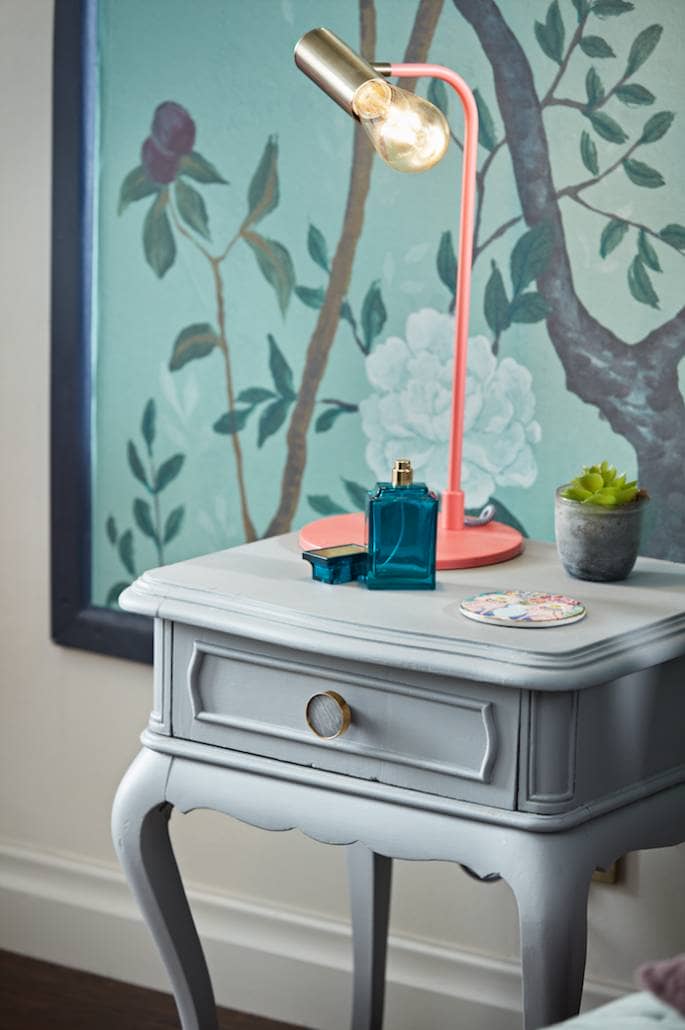 vintage side table in front of a mural wall
