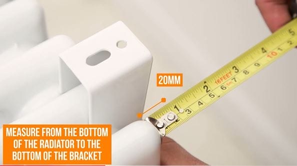 hand measuring a radiator bracket