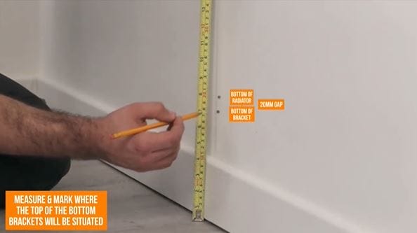 hand holding a pencil and tape measure