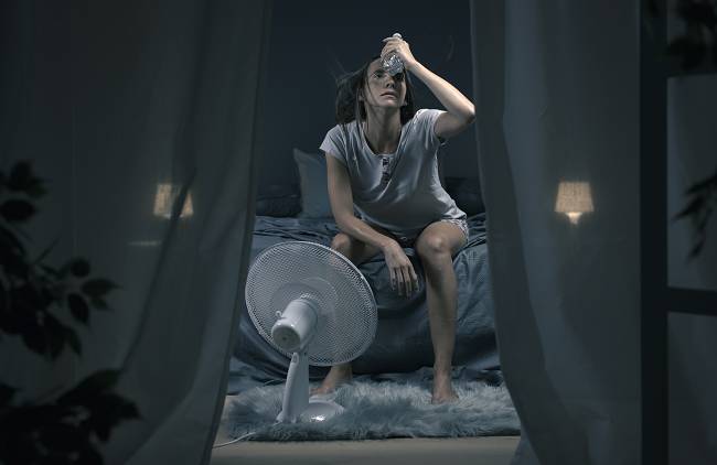 A woman sweating at nighttime in the middle of a summer heat wave