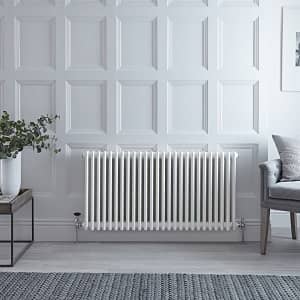 a traditonally styled white column radiator on a panelled wall