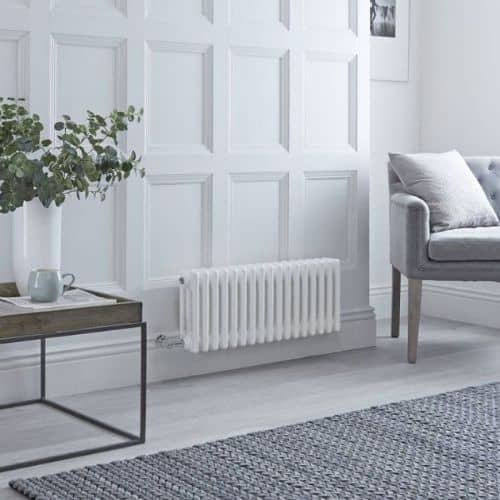 milano windsor low level wall mounted electric heater on a white wall next to a table