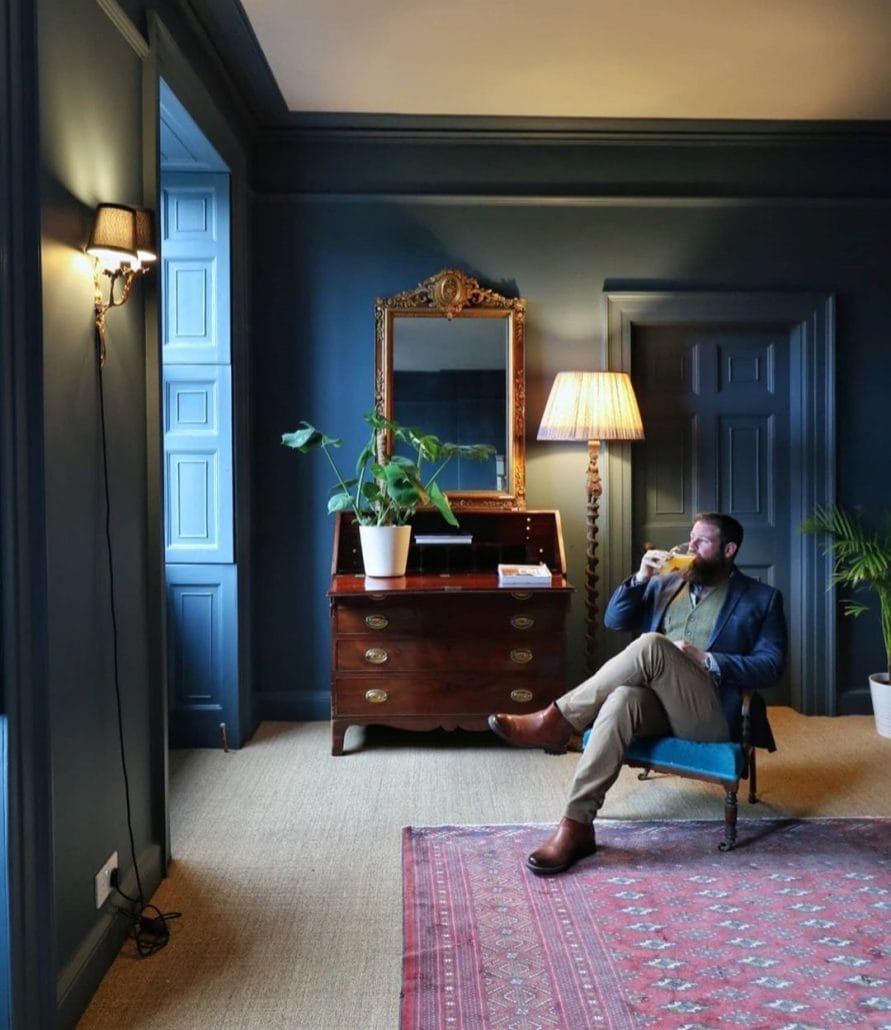 greg sat on a chair in a navy room