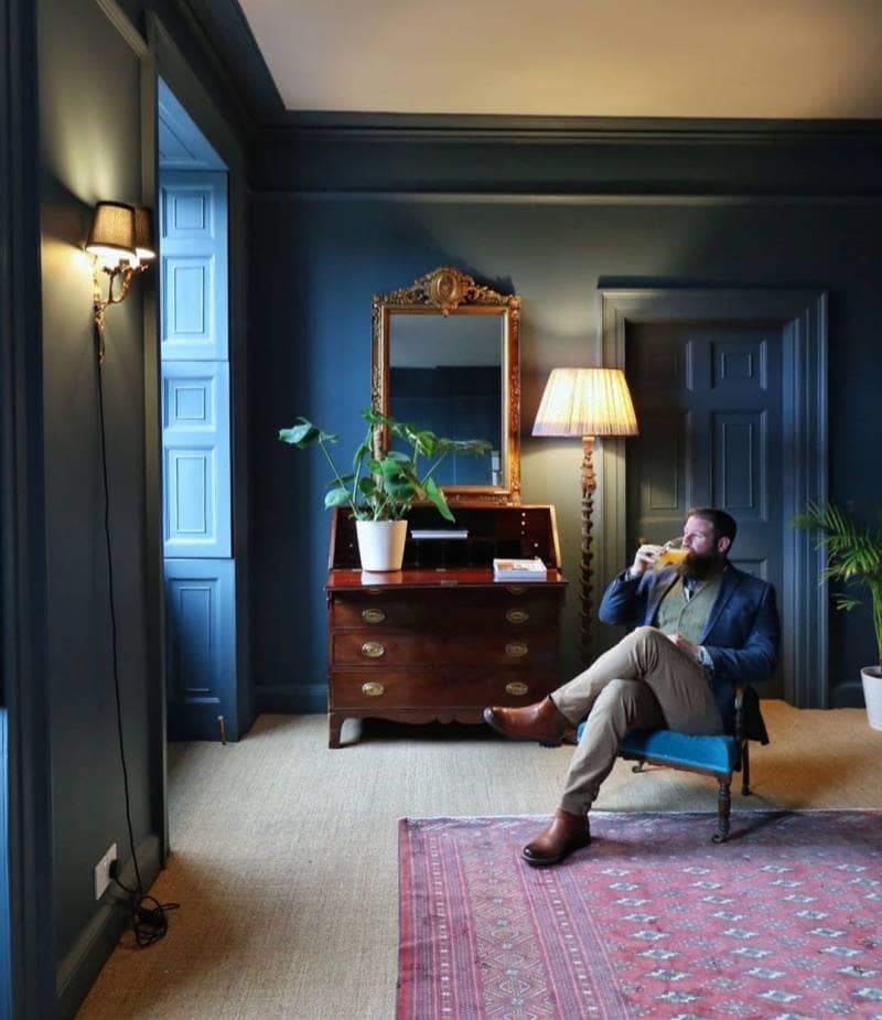 greg sat on a chair in a navy room