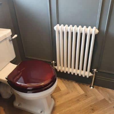 small white column radiator in a cloackroom
